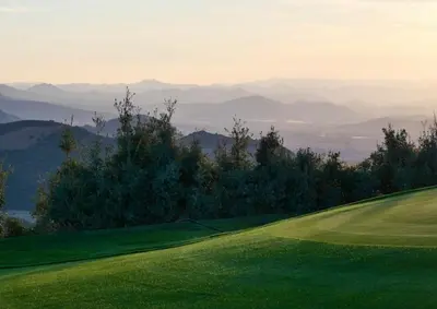 a green golf course with mountains in the background at Scandinavian Chalet in the Atlas Mountains - Ifrane in Ifrane
