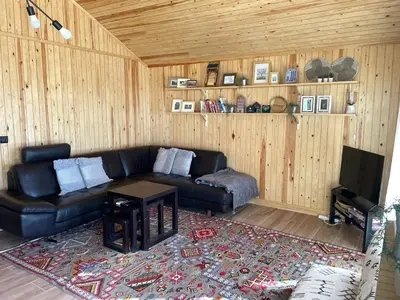 a living room with a black leather couch and a table at Scandinavian Chalet in the Atlas Mountains - Ifrane in Ifrane