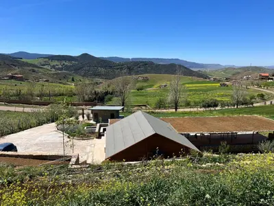 a building in a field with mountains in the background at Scandinavian Chalet in the Atlas Mountains - Ifrane in Ifrane