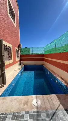 a swimming pool in front of a building at Rout ourika in Marrakech