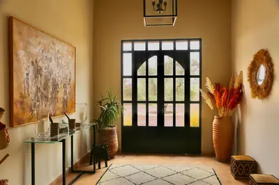 a room with a black door and a table with plants at Villa Beldi Chic Novari avec piscine chauffée - 8 personnes - Marrakech - Petit déjeuner inclus in Douarbel Kial