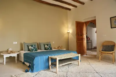 a bedroom with a bed and a table and a chair at Villa Beldi Chic Novari avec piscine chauffée - 8 personnes - Marrakech - Petit déjeuner inclus in Douarbel Kial