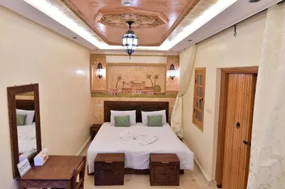 a bedroom with a bed and a mirror and a ceiling at Dar Chams Ouarzazate in Ouarzazate