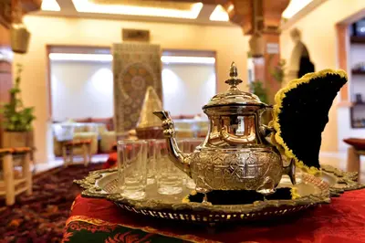 a silver tea kettle and glasses on a table at Dar Chams Ouarzazate in Ouarzazate