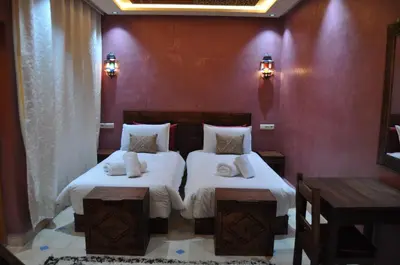 a bedroom with two beds with white sheets and pillows at Dar Chams Ouarzazate in Ouarzazate