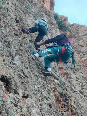 two people climbing up a rocky mountain at Chez Adam in Meknès