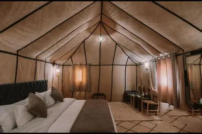 a bedroom with a bed in a tent at Chegaga Infinite Dunes Luxury Desert Camp in Mhamid