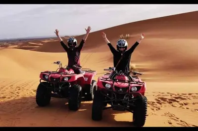 two people riding on atvs in the desert at Chegaga Infinite Dunes Luxury Desert Camp in Mhamid