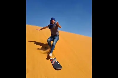 a man riding a skateboard in the desert at Chegaga Infinite Dunes Luxury Desert Camp in Mhamid