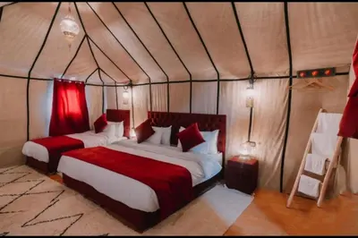 a bedroom with two beds in a tent at Chegaga Infinite Dunes Luxury Desert Camp in Mhamid