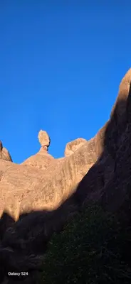 a rock formation with a blue sky in the background at Camping Restaurant Pattes des singes in Aït Ougliff