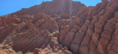 a large rocky mountain with a blue sky in the background at Camping Restaurant Pattes des singes in Aït Ougliff