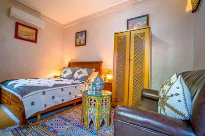 a bedroom with a bed and a table and a couch at Dar Lmrama - Entire House in Fes in Fès
