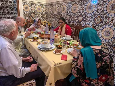 a group of people sitting around a table eating at Dar Lmrama - Entire House in Fes in Fès