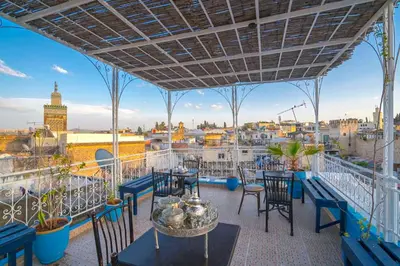 a balcony with tables and chairs and a view of the city at Dar Lmrama - Entire House in Fes in Fès