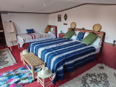 a bedroom with a large bed and a couch at Luxury Desert Camp Erg Chegaga in El Gouera