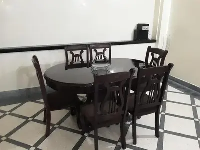 a dining room table with chairs and a black table at grand apt climatisé et ensoleillé au centre de Fès in Fès