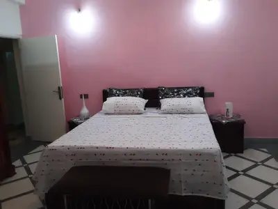 a bedroom with a large bed with a pink wall at grand apt climatisé et ensoleillé au centre de Fès in Fès