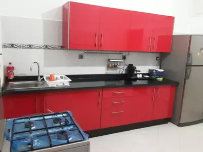 a red kitchen with a sink and red cabinets at grand apt climatisé et ensoleillé au centre de Fès in Fès