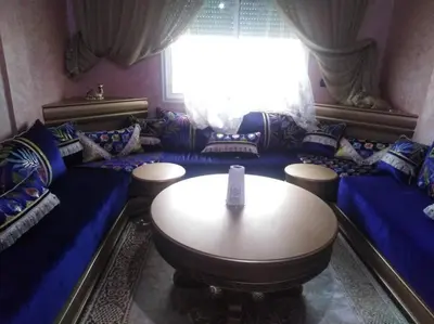 a living room with a table and blue couches at Top 4 Rooms Apartment in Beni Mellal