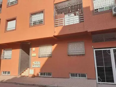 an orange building with barred windows on the side of it at Top 4 Rooms Apartment in Beni Mellal