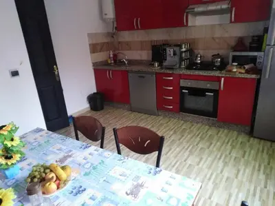 a kitchen with red cabinets and a table with fruit on it at Top 4 Rooms Apartment in Beni Mellal