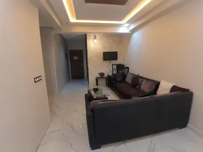 a living room with a couch and a television at Apartment Oued Fes close to Euromed in Fès