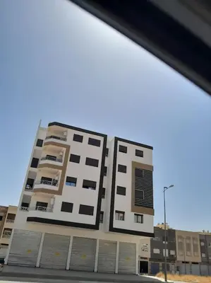a tall building with many windows on a street at Apartment Oued Fes close to Euromed in Fès