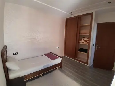 a small room with a bed and a cabinet at Apartment Oued Fes close to Euromed in Fès