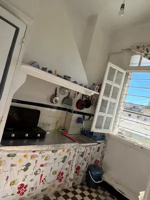 a small kitchen with a counter and a window at Chez Mia in Fès
