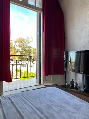 a bedroom with a bed and a large window at Chez Mia in Fès