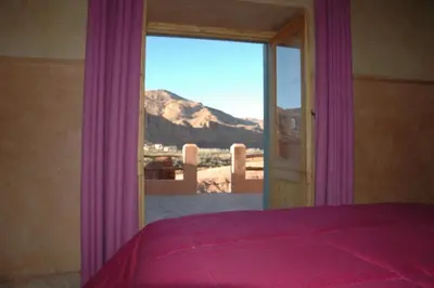 a bedroom with a window with a view of a mountain at kasbah De Alami hdida commune de ait ouassif kelaa mgouna tinghir in Kalaat MGouna