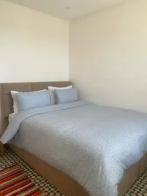 a bedroom with a bed with blue pillows at Appartement Fatima in Azrou