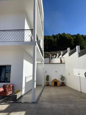 a white building with stairs and a patio at Appartement Fatima in Azrou