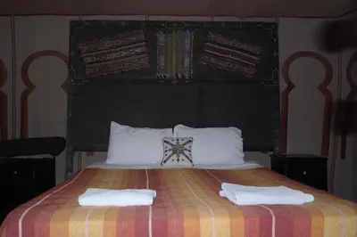 a bedroom with a large bed with two towels on it at Morocco Stars Camp in Hassilabied