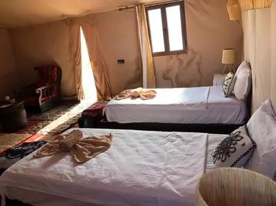 a bedroom with two beds and a window at Morocco Stars Camp in Hassilabied