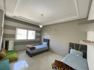 a room with two beds and a couch in it at Appartement spacieux in Fès
