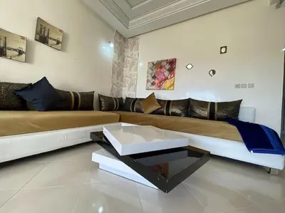 a living room with a couch and a coffee table at Appartement spacieux in Fès