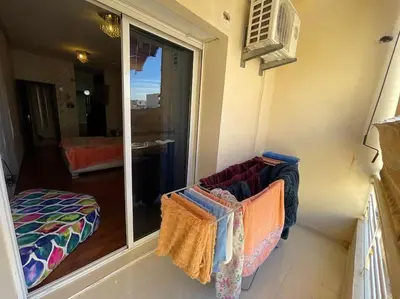 a room with a balcony with a chair and a window at Appartement spacieux in Fès
