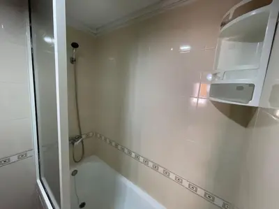 a white bathroom with a shower and a toilet at Appartement spacieux in Fès