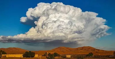 a large cloud formation in the sky over the desert at Sahara binich sercices in Merzouga