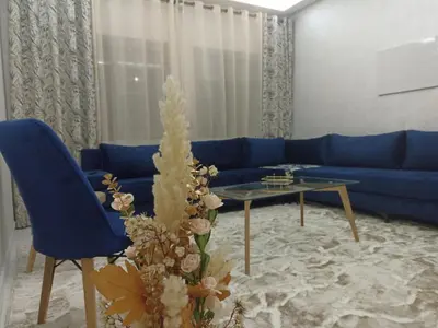 a living room with a blue couch and a table at Golden Mirage in Fès
