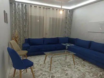 a blue couch and two chairs in a living room at Golden Mirage in Fès