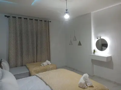 a bedroom with two twin beds and a mirror at Golden Mirage in Fès