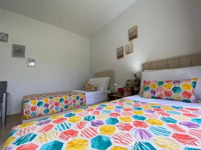 a bedroom with two beds with colorful sheets at Villa Joudia Royal Golf Fes in Fès