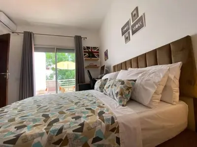 a bedroom with a large bed and a balcony at Villa Joudia Royal Golf Fes in Fès