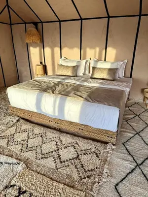 a bedroom with a large bed in a tent at Expérience Inoubliable dans une Tente de Luxe en plein Désert de Merzouga ! in Merzouga