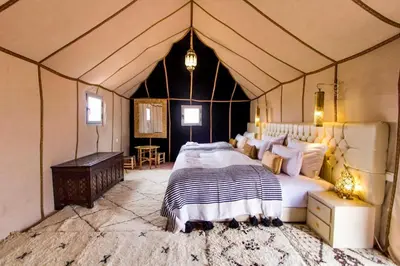 a bedroom with a large bed in a tent at Expérience Inoubliable dans une Tente de Luxe en plein Désert de Merzouga ! in Merzouga