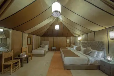 a bedroom with a bed and a couch and a table at Camp Luxueux en plein désert de Merzouga in Merzouga