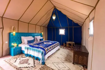 a bedroom with a bed in a tent at Camp Luxueux en plein désert de Merzouga in Merzouga